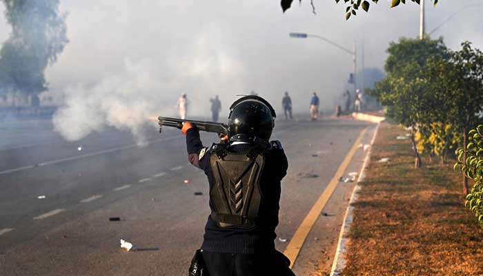 A policeman fires rubber bullets to disperse PTI supporters in Islamabad on November 26, 2024. — AFP