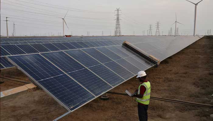 A technician checks the movement of an Automated cleaning brush installed over solar panels in Khavda Renewable Energy Park of Adani Green Energy Ltd in Khavda, India on  April 12, 2024. — Reuters