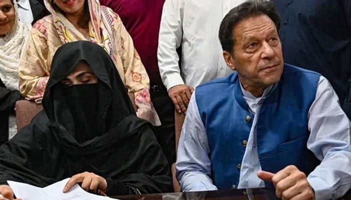 Former prime minister Imran Khan (right) along with his wife Bushra Bibi (centre) signs surety bonds for bail in various cases, at the registrars office in the Lahore High Court on July 17, 2023. — AFP