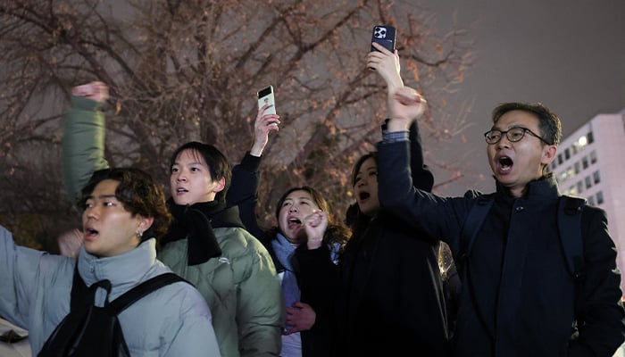 People shout slogans in front of the gate of the National Assembly, after South Korean President Yoon Suk Yeol declared martial law, in Seoul, South Korea, December 4, 2024. — Reuters