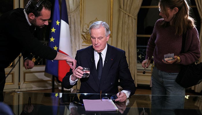 Frances Prime Minister Michel Barnier receives makeup touch-ups prior to a televised interview broadcast on French TV channels TF1 and France 2, at Hotel Matignon in Paris, France, December 3, 2024.