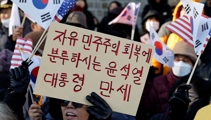 A protester holds a placard during a rally supporting South Korean President Yoon Suk Yeol and denouncing opposition partys politicians after the Presidents surprise declaration of the martial law last night in Seoul, South Korea, December 4, 2024. — Reuters