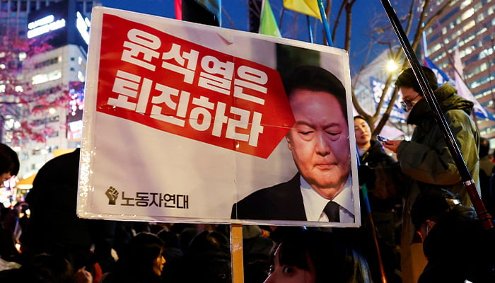 A protester holds a placard during a rally to condemn South Korean President Yoon Suk Yeols surprise declaration of martial law in Seoul, South Korea, December 4, 2024. — Reuters