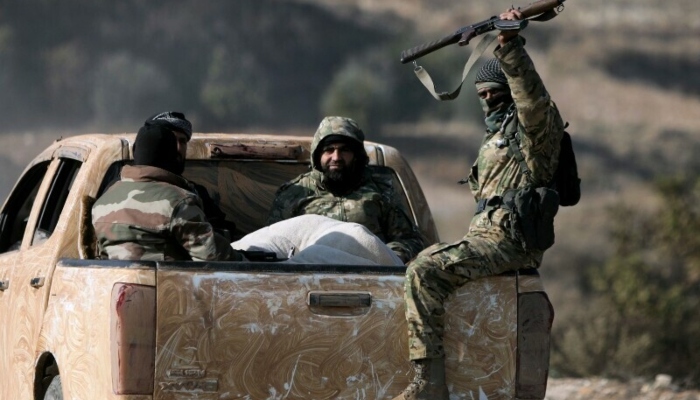 Anti government fighters ride in the back of a pick truck in the town of Suran, between Aleppo and Hama, on December 3. —AFP