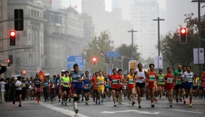 Participants run at the Bund near the Huangpu River as they compete during the Shanghai International Marathon on November 2, 2014. —Reuters