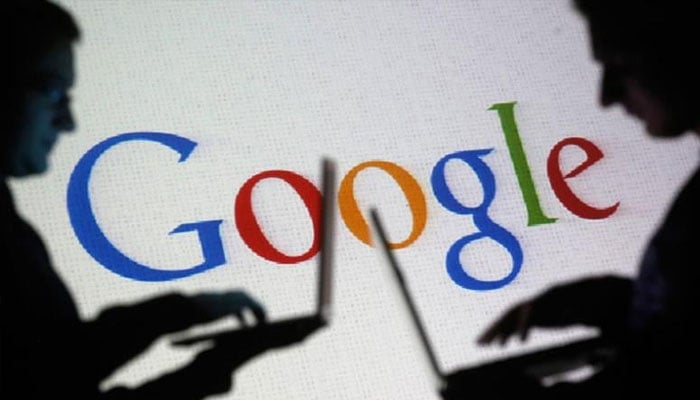 People seen using their laptops with the Google logo in the background. — Reuters/File