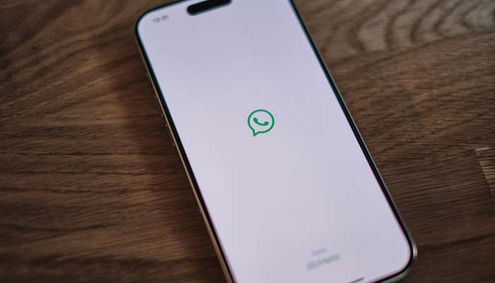 A representational image shows the WhatsApp app displayed on a phone screen. — Unsplash