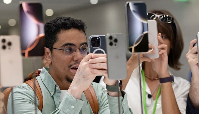 An attendee takes a photo of the new iPhone 16 as Apple holds an event at the Steve Jobs Theater on its campus in Cupertino, California, US September 9, 2024. — Reuters