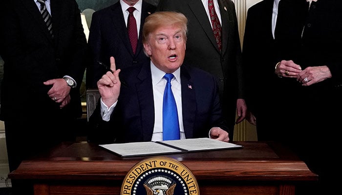 US President-elect Donald Trump, surrounded by business leaders and administration officials, prepares to sign a memorandum on intellectual property tariffs on high-tech goods from China, at the White House in Washington, US March 22, 2018. — Reuters