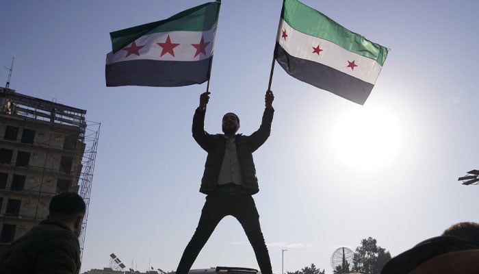 A man holds the Syrian opposition flag as they celebrate after Syrias army command notified officers on Sunday that President Bashar al-Assads 24-year authoritarian rule has ended, a Syrian officer who was informed of the move told Reuters, following a rapid rebel offensive that took the world by surprise, in Aleppo, Syria December 8, 2024. — Reuters