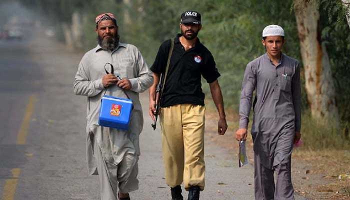 A policeman walks alongside a polio vaccination worker during an inoculation campaign in this undated image. — Reuters/File