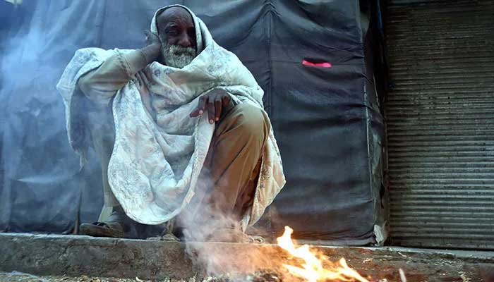 Representational image of an old man sitting near fire to keep warm in cold weather on December 10, 2024. — INP