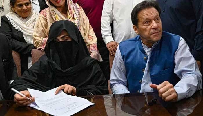 Former prime minister Imran Khan along with his wife Bushra Bibi signs surety bonds for bail in various cases, at the registrars office in the Lahore High Court on July 17, 2023. — AFP