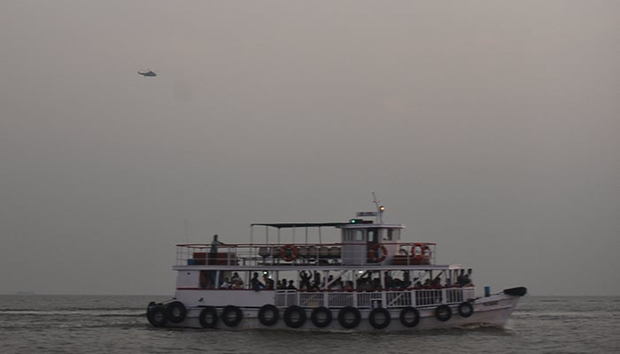 A military helicopter flies over a ferry during a rescue operation after a passenger boat capsized off the coast of Indias financial capital Mumbai, India, December 18, 2024. — Reuters