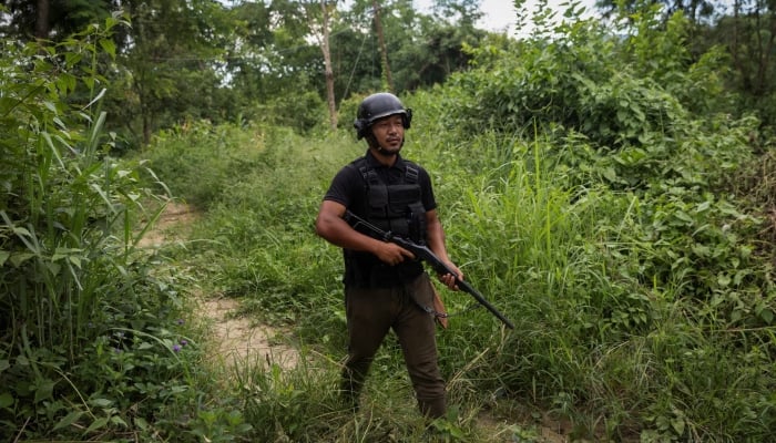 Seikhogan, 30, an armed Kuki man, walks as he guards a village in Churachandpur district in the northeastern state of Manipur, India, July 23. — Reuters