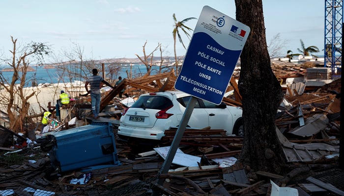 People clean the debris around the destroyed houses in the aftermath of Cyclone Chido, in Mamoudzou, Mayotte, France December 20, 2024. — Reuters