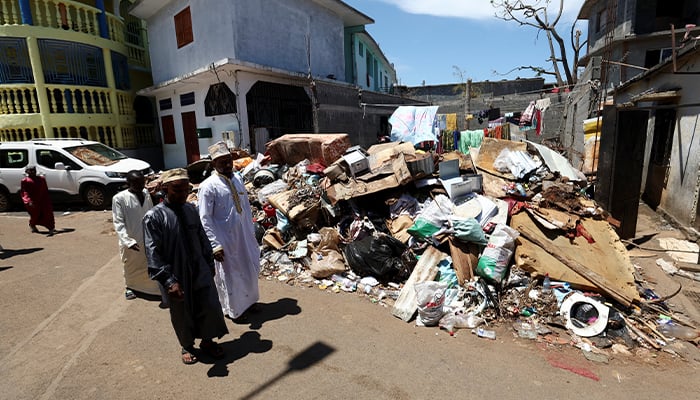 People walk past the rubble, on the day of Friday prayers, in the aftermath of Cyclone Chido, in Kaweni, Mayotte, December 20, 2024. — Reuters