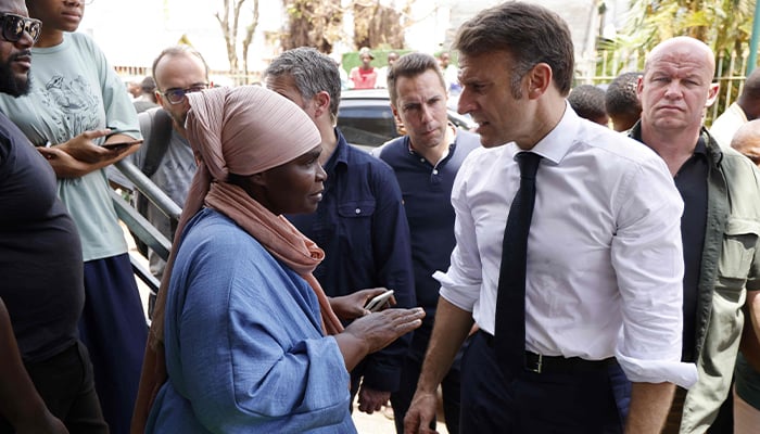 Frances President Emmanuel Macron speaks with local residents during his visit to a neighbourhood in Tsingoni, on the French Indian Ocean territory of Mayotte on December 20, 2024, following the cyclone Chidos passage over the archipelago. — AFP