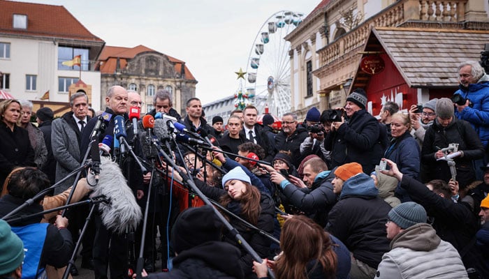 German Chancellor Olaf Scholz (L) speaks to the press during a visit to the site of a car-ramming attack on a Christmas market in Magdeburg, eastern Germany, on December 21, 2024. — AFP