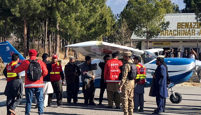 Relawan Yayasan Edhi mengepung pesawat yang membawa obat-obatan untuk korban luka dalam bentrokan di distrik KPs Kurram di Parachinar pada 17 Desember 2024. — AFP