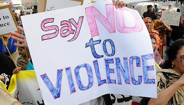 A representational image of women holding a placard that reads Stop Gender Based Violence. — AFP/File