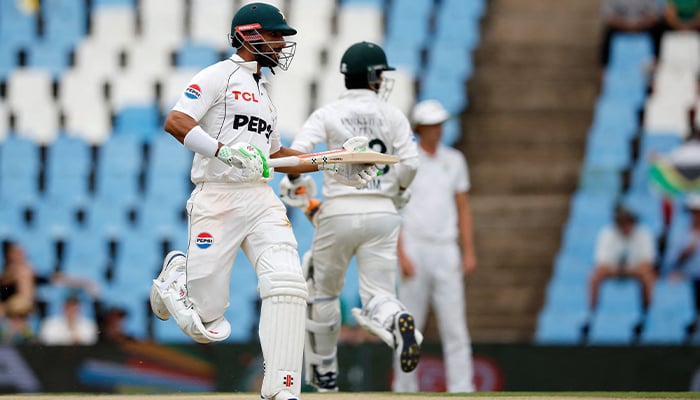 Pakistan´s Shan Masood (L) and Pakistan´s Saim Ayub (R) runs between the wickets during the second day of the first cricket Test match between South Africa and Pakistan at SuperSport Park in Centurion on December 27, 2024. — AFP