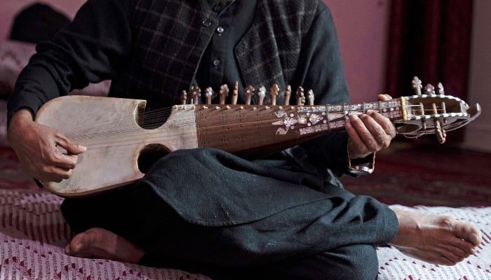 In this photograph taken on December 17, 2024, Afghan musician Majid plays the rubab instrument at a house in Kabul, Afghanistan. — AFP