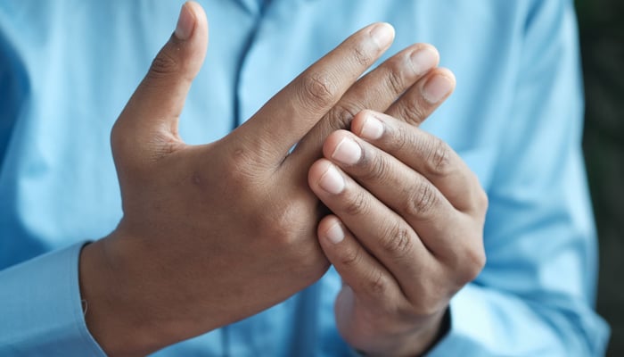 A man massaging his fingers due to pain. — Unsplash/File