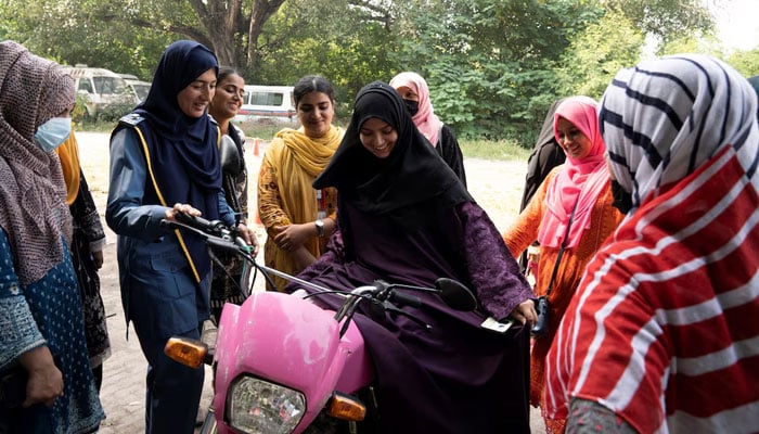 A traffic warden, teaches women how to ride a bike during a training session as part of the Women on Wheels program organised by the traffic police department in Lahore on October 1, 2024. — Reuters