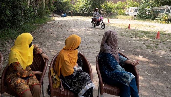 shrat Khan practices riding a motorbike as others watch her, during a training session as part of the Women on Wheels program organised by the traffic police department in Lahore on October 1, 2024. — Reuters