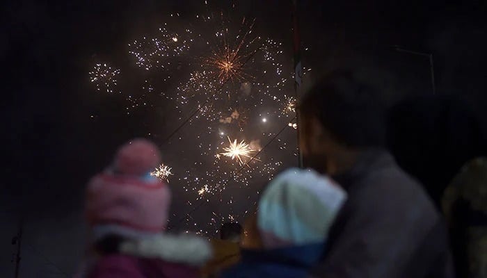 Revellers watch a fireworks show during New Year celebrations in Karachi. — AFP/File