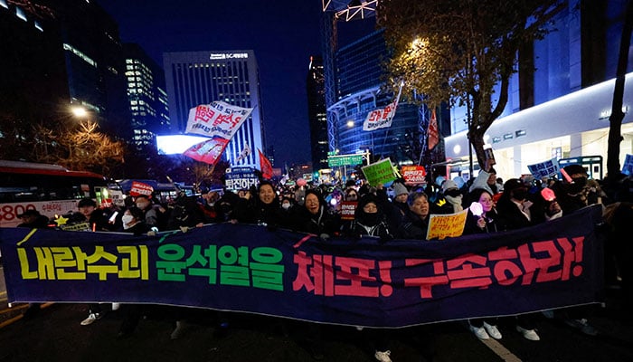 Protesters hold a banner reading Arrest the insurrectionist Yoon Suk Yeol! as they march during a rally against South Koreas impeached President Yoon Suk Yeol, who declared martial law, which was reversed hours later, in Seoul, South Korea, December 28, 2024. — Reuters