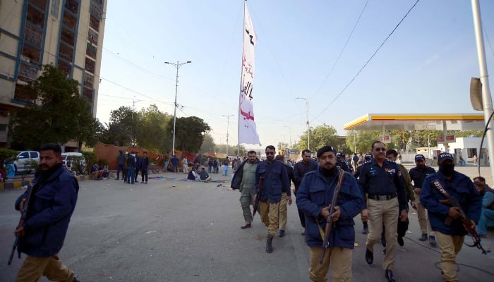 Police officials stand alert during protest demonstration of MWM on Sharea-e-Faisal road in Karachi on December 29, 2024. — PPI