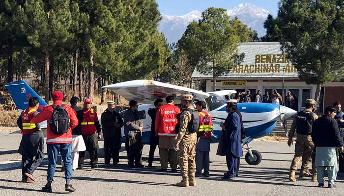 Volunteers of private welfare organisation Edhi with security personnel surround aplane carrying medicines for victims injured in clashes, upon its arrival in Parachinar, at Kurram district, Khyber Pakhtunkhwa on December 17, 2024. — AFP