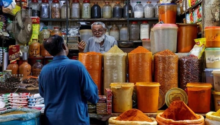 A shopkeeper speaks with a customer while selling spices at a market in Karachi, Pakistan June 11, 2024.— Reuters