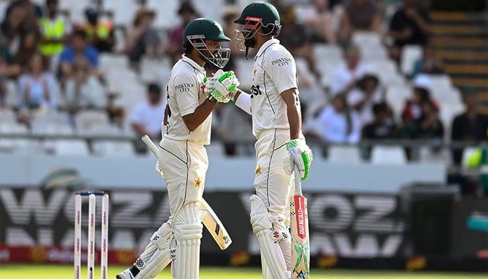 Pakistans Babar Azam (L) and Shan Masood (R) celebrate their 200 runs partnership during the third day of the second international Test cricket match between South Africa and Pakistan at Newlands stadium in Cape Town on January 5, 2025. — AFP