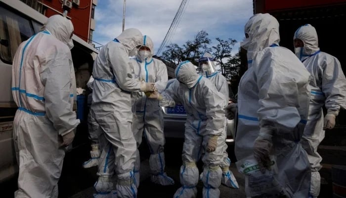 Pandemic prevention workers in protective suits prepare to enter an apartment compound in Beijing, China, November 12, 2022. — Reuters