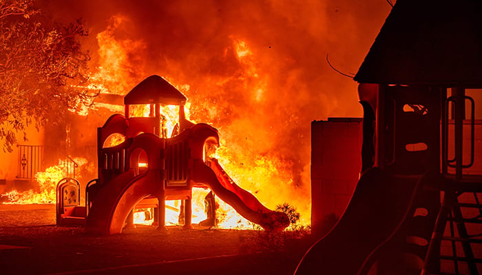 A playground burns in a residential neighborhood during the Eaton fire in Pasadena, California on January 7, 2025. — AFP