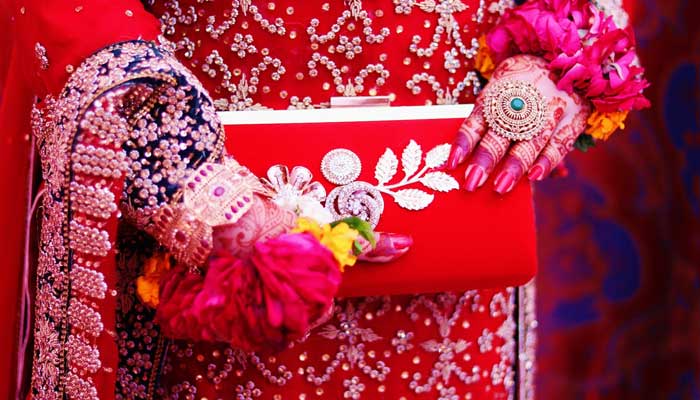 A representational image shows a Pakistani bride holding her purse. — Unsplash/File