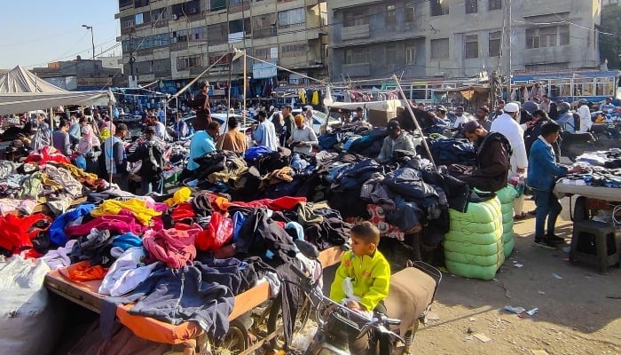 People purchasing warm clothes from a bazaar in Karachi. — INP/File