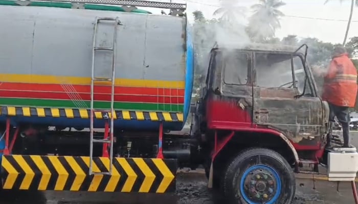 A firefighter is trying to douse the fire in the truck involved in the accident in Karachi on January 10, 2025. — Screengrab/Reporter