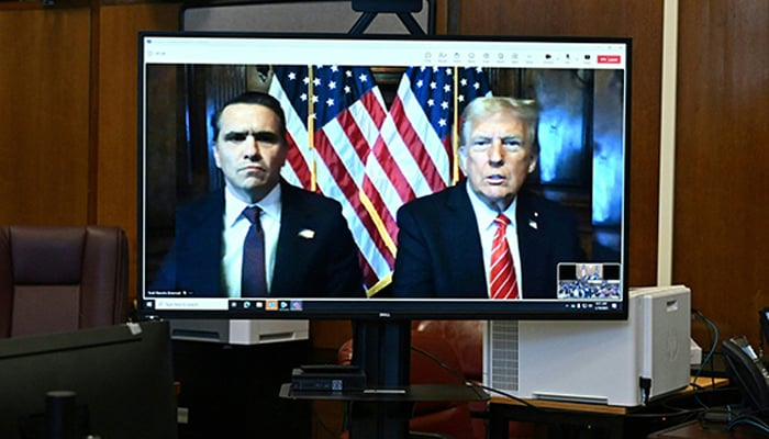 Todd Blanche, attorney for former US President Donald Trump (left), and US President-elect Donald Trump are seen on the screen at Manhattan criminal court in New York, on January 10, 2025. — AFP