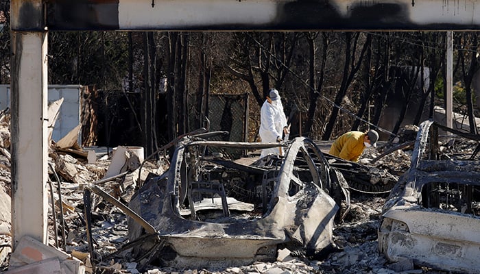 Warga menggali sisa-sisa rumah mereka di Pacific Palisades, setelah Kebakaran Palisades menghanguskan banyak rumah, di Los Angeles County, California, AS, 12 Januari 2025. — Reuters