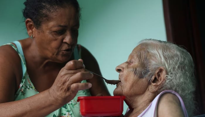 Doroteia Ferreira da Silva, 60, feeds her grandmother Deolira Gliceria Pedro da Silva, 119, in her house in Itaperuna, Rio de Janeiro state, Brazil, on January 14, 2025. — Reuters