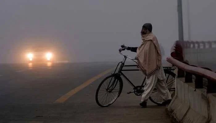 A man draped in a shawl makes his way across a bridge in Karachi. — AFP/File