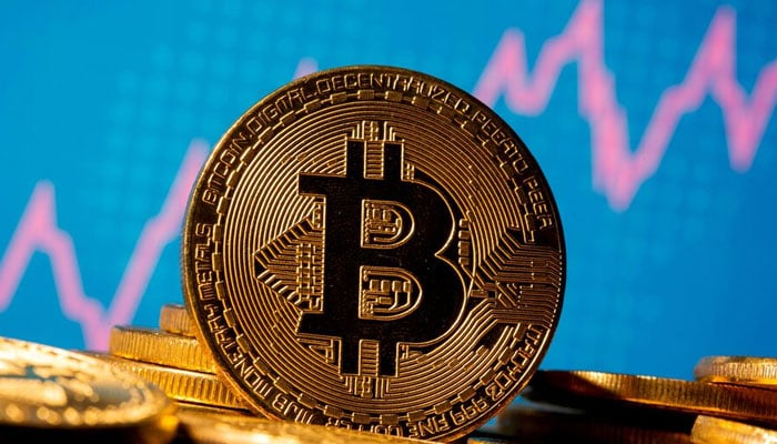 A representation of virtual currency bitcoin is seen in front of a stock graph in this illustration taken on November 19, 2020. — Reuters