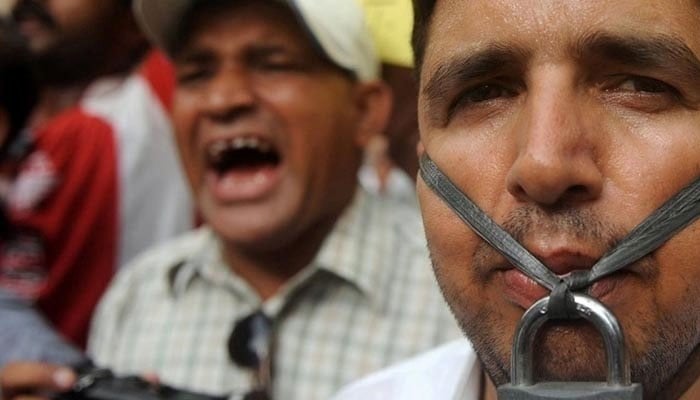 A man poses for a picture with a padlock in his mouth during a protest against curb on freedom of expression in this undated image. — AFP/File