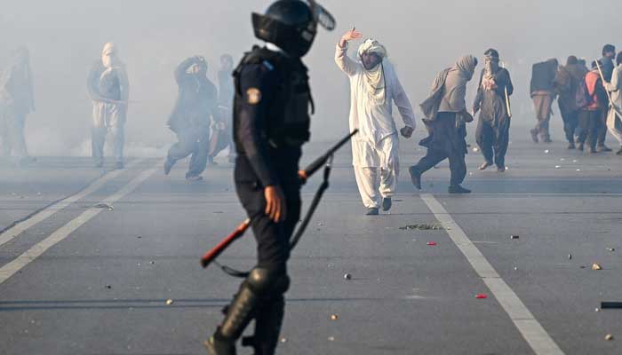 A PTI supporter gestures after tear gas was fired by the police to disperse the crowd in Islamabad, November 26. — AFP