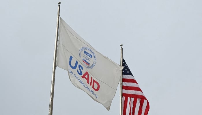 A USAID and American flag fly outside of USAID headquarters in Washington, DC, on February 3, 2025. — AFP