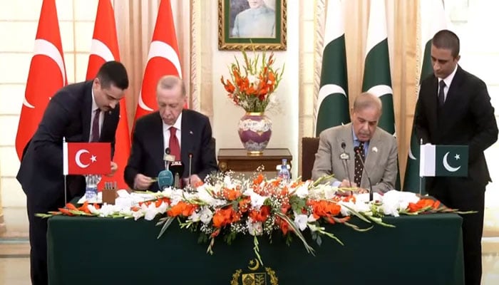 Prime Minister Shehbaz Sharif (right) and Turkish President Recep Tayyip Erdogan sign an agreement in Islamabad on February 13, 2025. YouTube/Geo News/screengrab